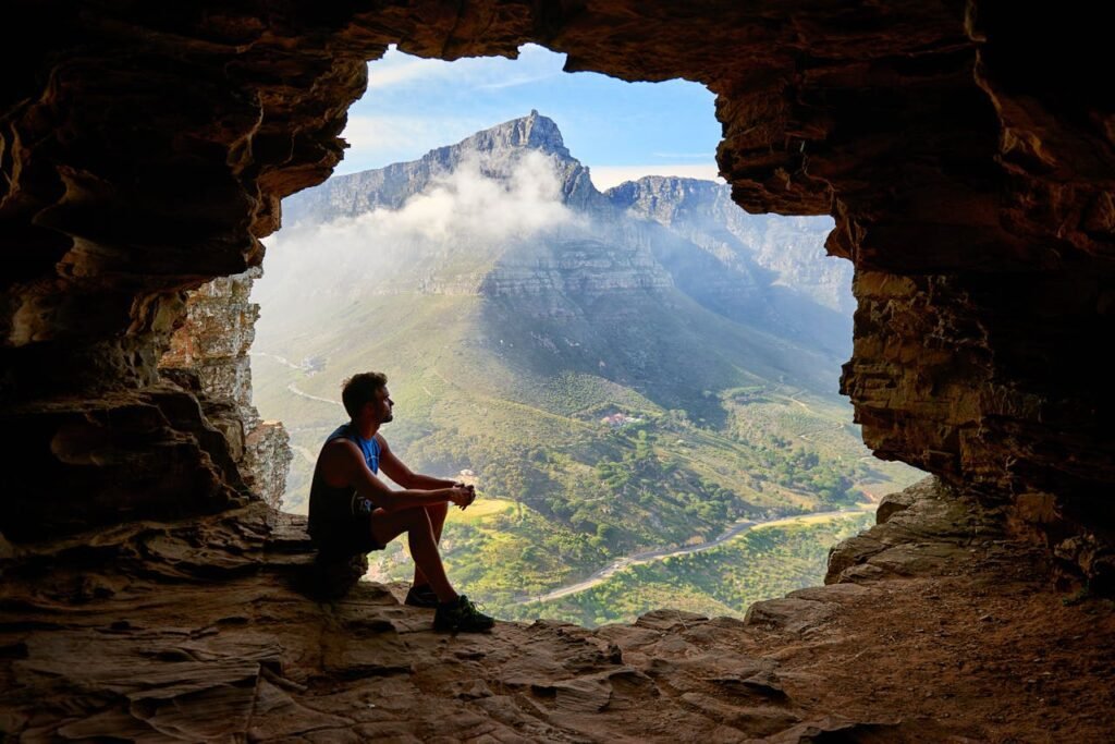 photo of man sitting on a cave 1659437